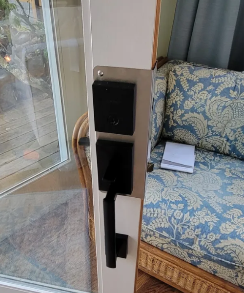 A door handle on a door with a couch in the background